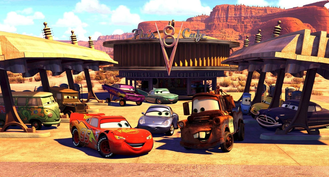 Flash McQueen, Martin, Sally, Doc Hudson et d'autres habitants de Radiator Springs réunis en plein soleil devant le Flo's V8 Café.